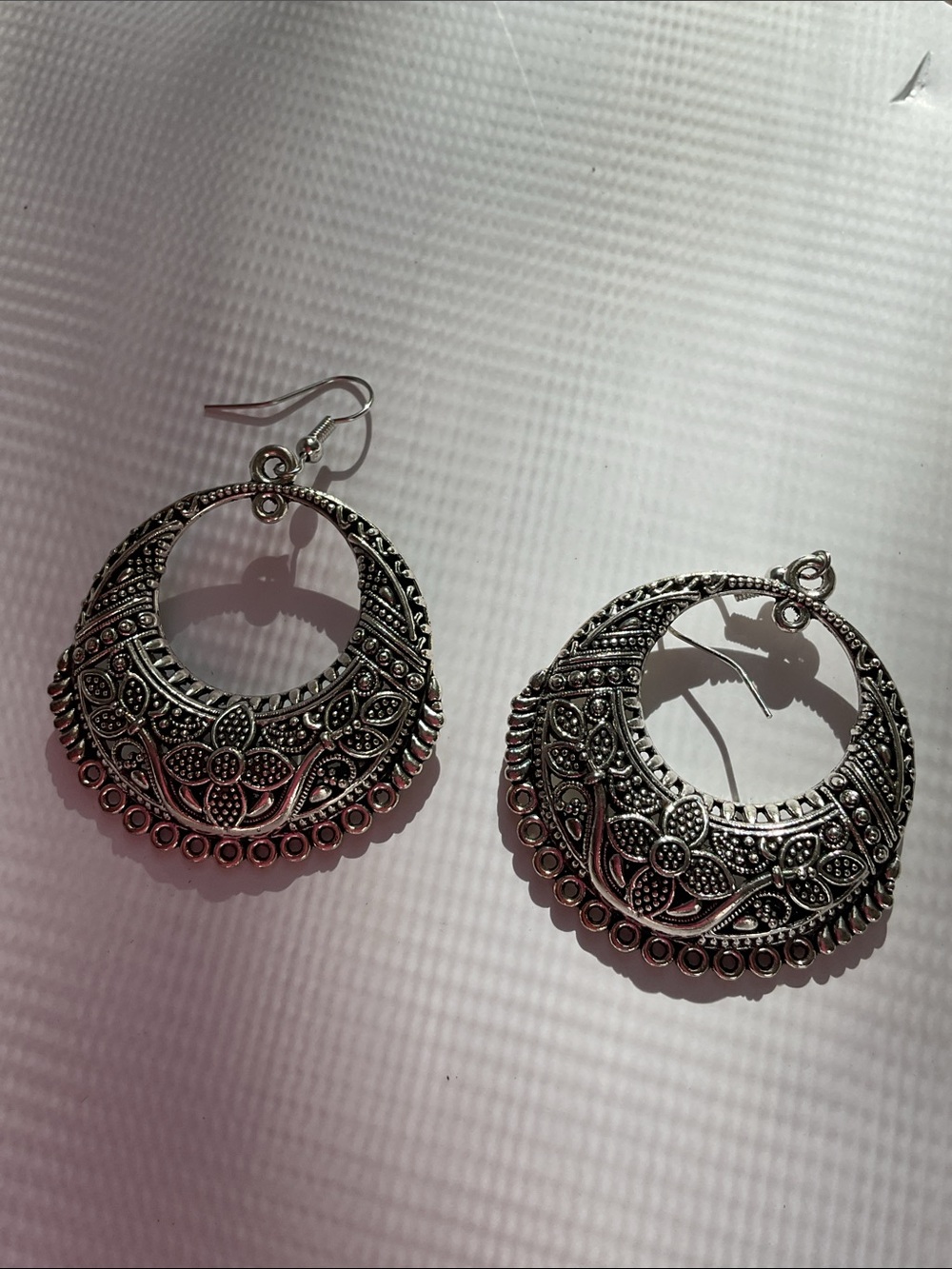 Intricate silver tone earrings. Sanitized and in as new condition.